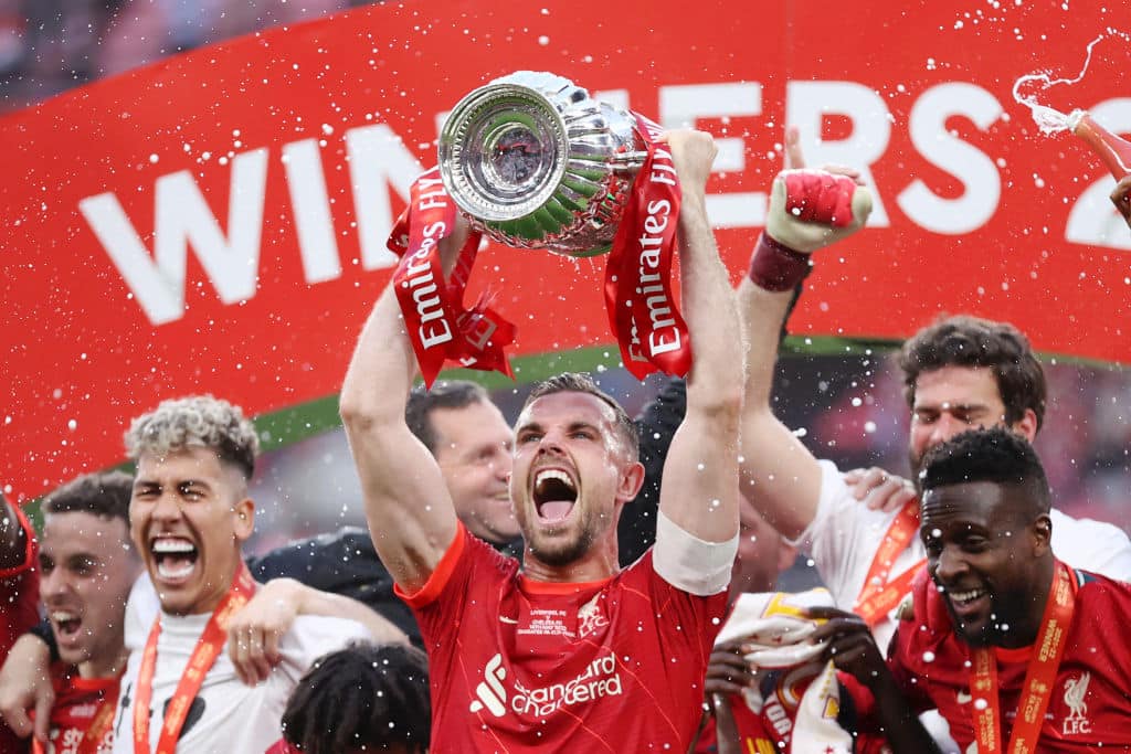 LONDON, ENGLAND - MAY 14: Jordan Henderson of Liverpool lifts The Emirates FA Cup trophy after their sides victory during The FA Cup Final match between Chelsea and Liverpool at Wembley Stadium on May 14, 2022 in London, England.