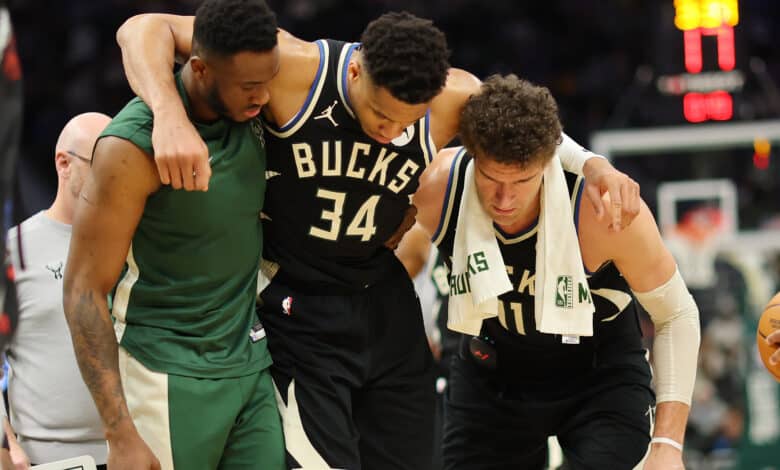 MILWAUKEE, WISCONSIN - APRIL 09: Giannis Antetokounmpo #34 of the Milwaukee Bucks is helped off the court by Thanasis Antetokounmpo #43 and Brook Lopez #11 after suffering an injury during the second half of a game against the Boston Celtics at Fiserv Forum on April 09, 2024 in Milwaukee, Wisconsin.