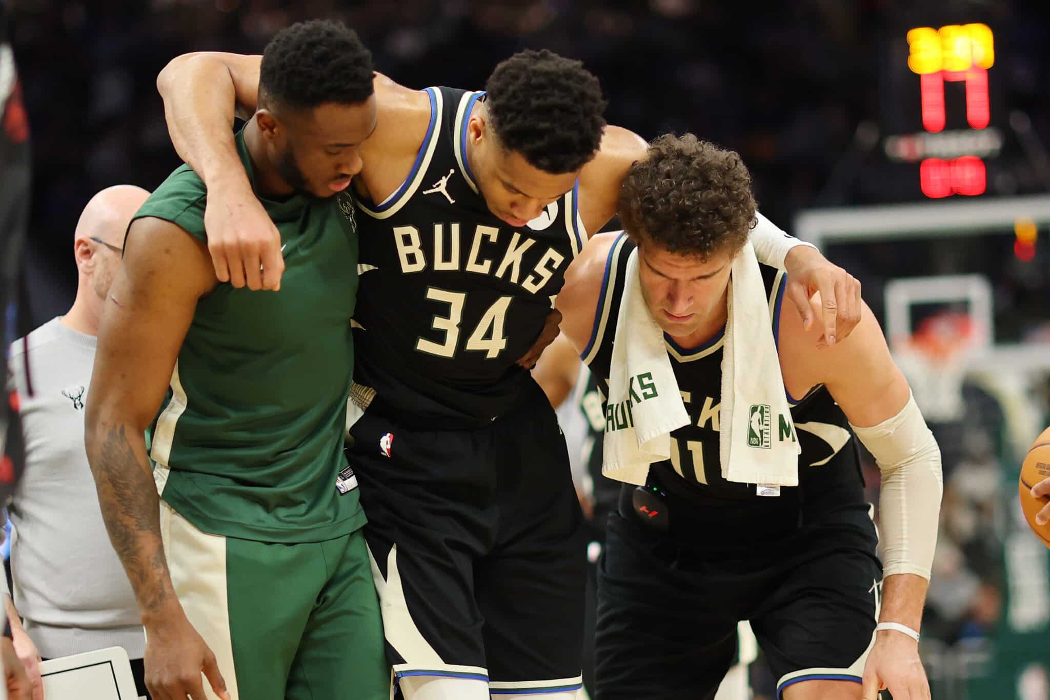 MILWAUKEE, WISCONSIN - APRIL 09: Giannis Antetokounmpo #34 of the Milwaukee Bucks is helped off the court by Thanasis Antetokounmpo #43 and Brook Lopez #11 after suffering an injury during the second half of a game against the Boston Celtics at Fiserv Forum on April 09, 2024 in Milwaukee, Wisconsin.