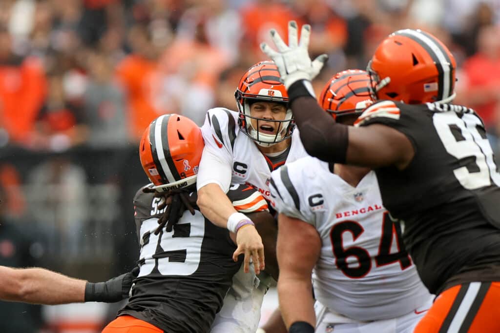 CLEVELAND, OH - SEPTEMBER 10: Cincinnati Bengals quarterback Joe Burrow (9) is hit by Cleveland Browns defensive end Za'Darius Smith (99) after throwing a pass during the third quarter of the National Football League game between the Cincinnati Bengals and Cleveland Browns on September 10, 2023, at Cleveland Browns Stadium in Cleveland, OH.