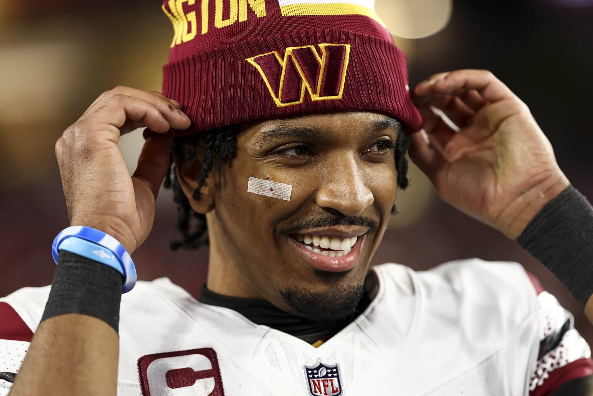 Jayden Daniels #5 of the Washington Commanders smiles after an NFL football wild card playoff game against the Tampa Bay Buccaneers