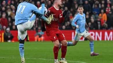 Manchester City's Belgian midfielder #11 Jeremy Doku (L) kicks Liverpool's Argentinian midfielder #10 Alexis Mac Allister during the English Premier League football match between Liverpool and Manchester City at Anfield in Liverpool, north west England on March 10, 2024
