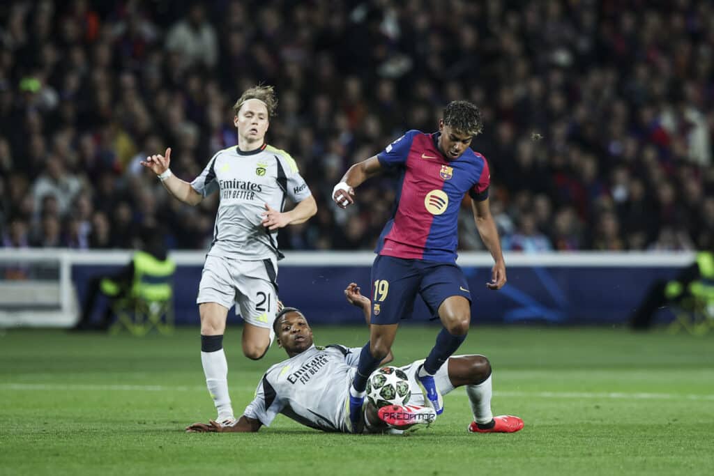 Barcelona, Spain - March 11: Lamine Yamal of FC Barcelona controls the ball defended by SL Benfica players during the UEFA Champions League 2024/25 Round of 16 Second Leg match between FC Barcelona and SL Benfica at Estadi Olímpic Lluís Companys on March 11, 2025 in Barcelona, Spain.