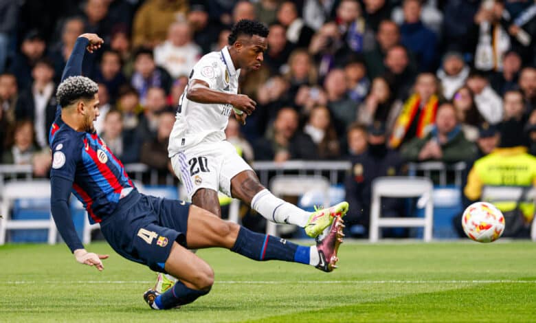 Vinicius Junior player of Real Madrid kicks the ball as Ronald Araujo of Barcelona slides during the Copa Del Rey Semi Final