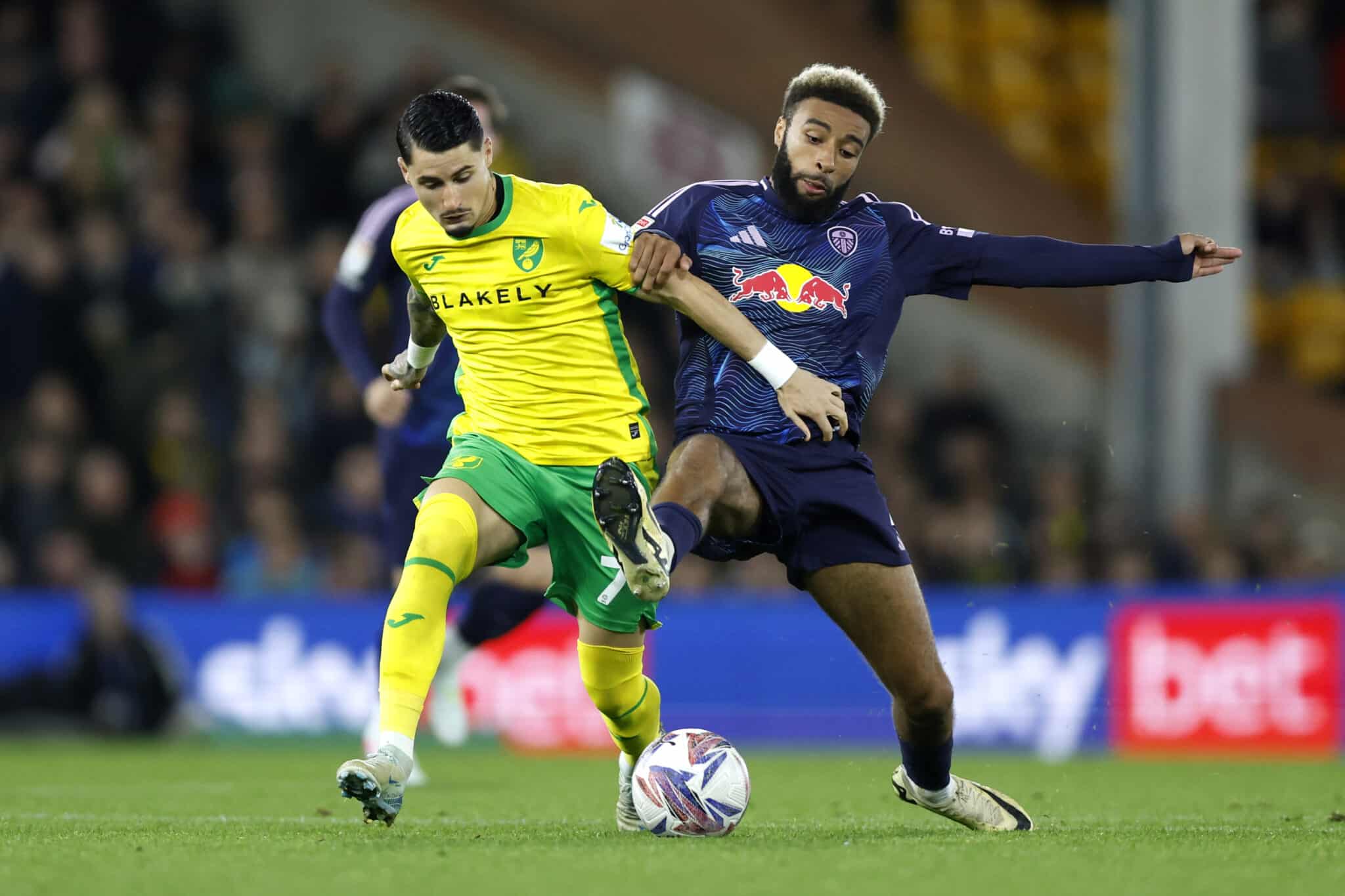 Norwich City's Borja Sainz (right) and Leeds United's Jayden Bogle battle for the ball during the Sky Bet Championship match at Carrow Road, Norwich. Picture date: Tuesday October 1, 2024.