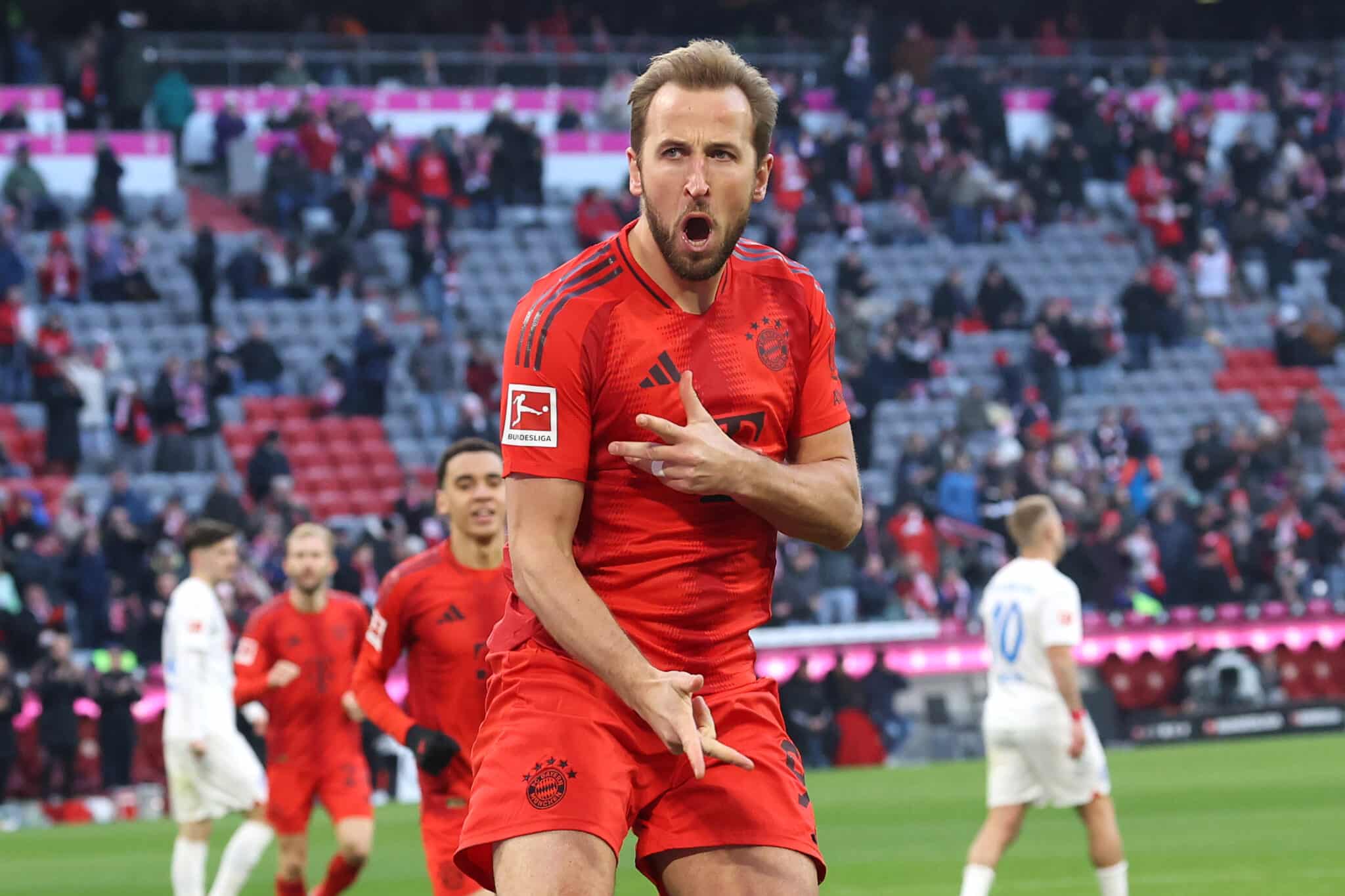 Harry Kane of Bayern Munich celebrates scoring his team's third goal during the Bundesliga match between FC Bayern München and Holstein Kiel