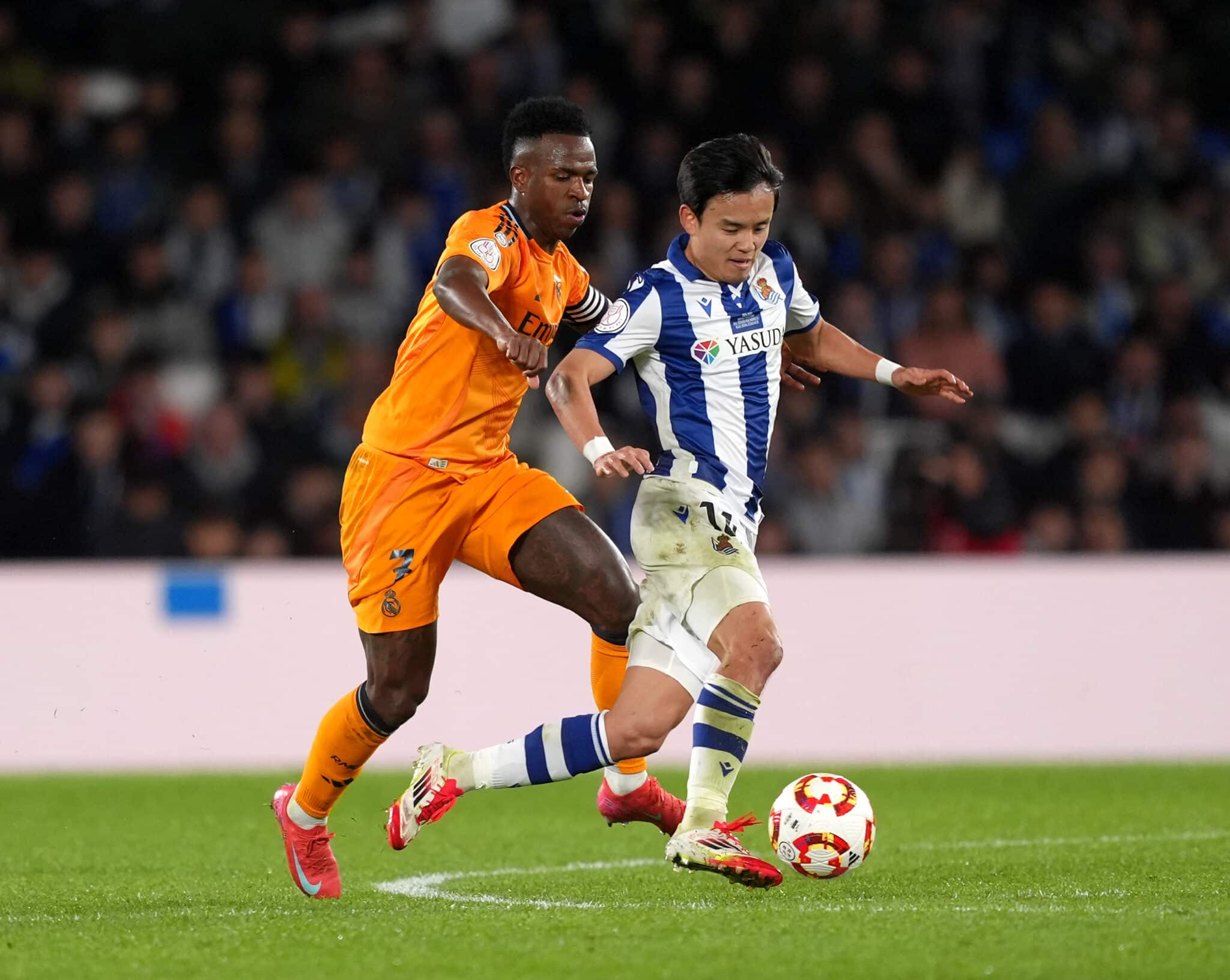 Vinicius Junior of Real Madrid battles for possession with Takefusa Kubo of Real Sociedad during the Copa del Rey Semi Final match