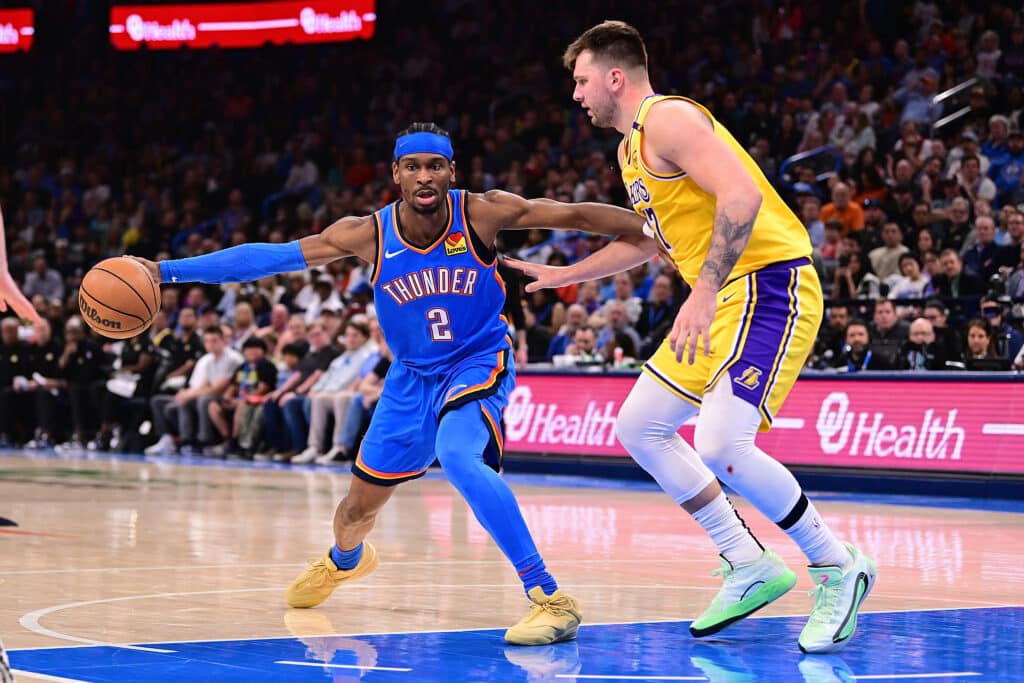 OKLAHOMA CITY, OKLAHOMA - APRIL 8: Shai Gilgeous-Alexander #2 of the Oklahoma City Thunder handles the ball in front of Luka Doncic #77 of the Los Angeles Lakers during the first half at Paycom Center on April 8, 2025 in Oklahoma City, Oklahoma.
