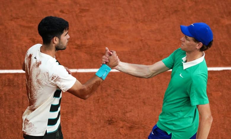 US Open - TOPSHOT - Spain's Carlos Alcaraz (L) shakes hands with Italy's Jannik Sinner after winning the men's singles final match on day 15 of the French Open tennis tournament on Court Philippe-Chatrier at the Roland-Garros Complex in Paris on June 8, 2025. (Photo by Dimitar DILKOFF / AFP)