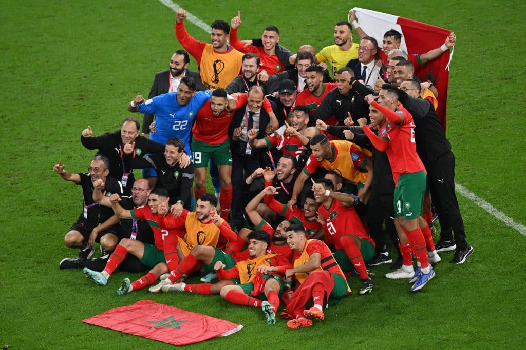 TOPSHOT - Morocco's players pose for pictures after qualifying to the next round by defeating Portugal 1-0 in the Qatar 2022 World Cup quarter-final football match between Morocco and Portugal at the Al-Thumama Stadium in Doha on December 10, 2022.