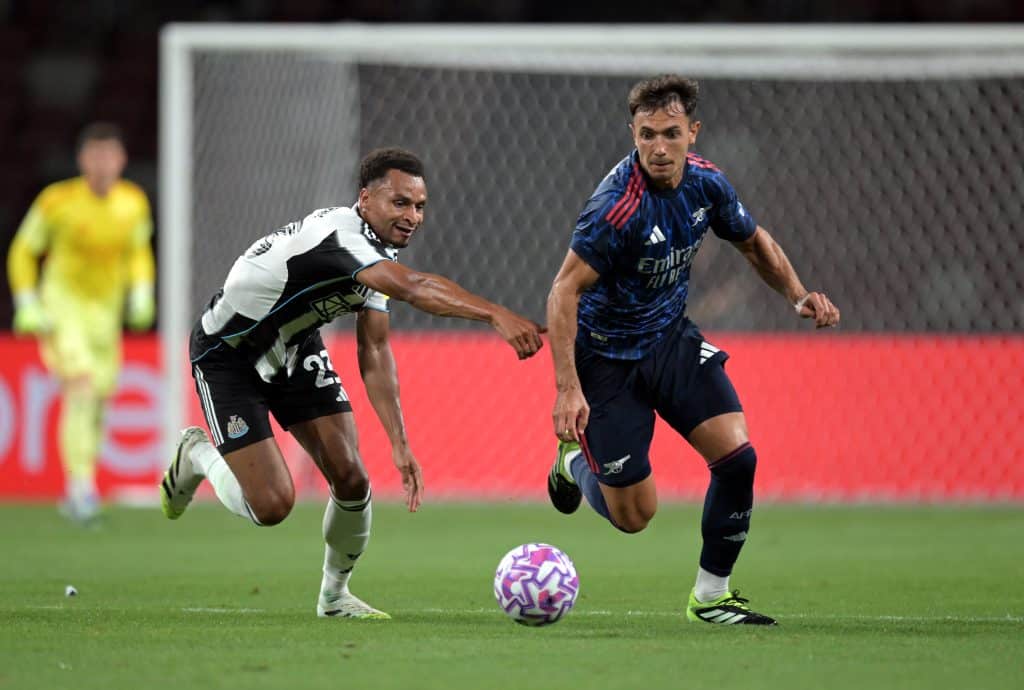 SINGAPORE, SINGAPORE - JULY 27: Martin Zubimendi of Arsenal runs with the ball whilst under pressure from Jacob Murphy of Newcastle United during the Pre-Season Friendly between Arsenal FC and Newcastle United at The Singapore National Stadium on July 27, 2025 in Singapore. 