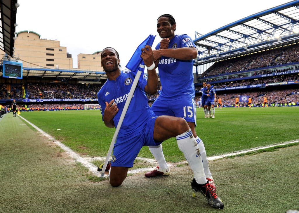 LONDON, ENGLAND - MAY 09: Didier Drogba of Chelsea celebrates with teammate Florent Malouda after completing his hat trick and scoring his team's seventh goal during the Barclays Premier League match between Chelsea and Wigan Athletic at Stamford Bridge on May 9, 2010 in London, England.
