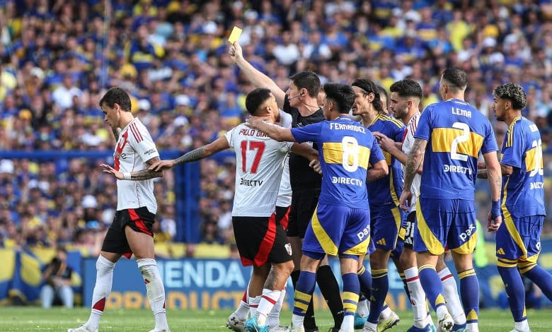 BUENOS AIRES, ARGENTINA - SEPTEMBER 21: Referee Nicolas Ramirez shows a yellow card to Nicolás Fonseca of River Plate during the Liga Profesional 2024 match between Boca Juniors and River Plate at Estadio Alberto J. Armando on September 21, 2024 in Buenos Aires, Argentina.
