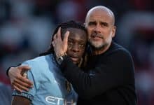 Jeremy Doku of Manchester City interacts with Pep Guardiola, Manager of Manchester City
