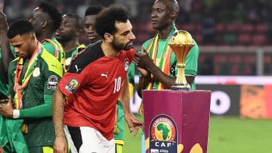 Egypt's forward Mohamed Salah walks past the trophy after losing the Africa Cup of Nations (AFCON) 2021 final