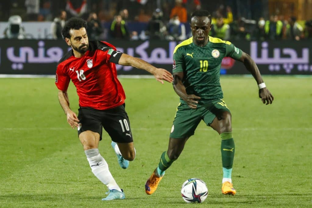 Egypt's forward Mohamed Salah (L) vies for the ball against Senegal's forward Sadio Mane (R) during the 2022 Qatar World Cup African Qualifiers football match between Egypt and Senegal at Cairo International Stadium in the Egyptian capital on March 25, 2022. 