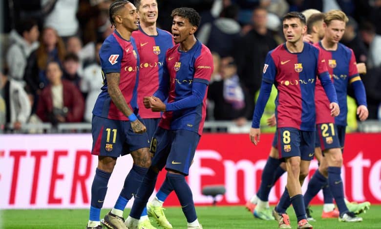 MADRID, SPAIN - OCTOBER 26: Raphinha of FC Barcelona celebrates scoring his team's fourth goal with teammates Robert Lewandowski and Lamine Yamal during the LaLiga match between Real Madrid CF and FC Barcelona at Estadio Santiago Bernabeu on October 26, 2024 in Madrid, Spain.
