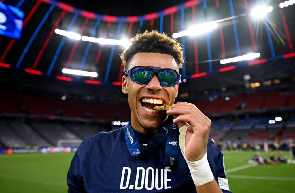 MUNICH, GERMANY - MAY 31: Desire Doue of Paris Saint-Germain bites his Winners Medal after his team's victory, to secure Paris Saint-Germain's first ever UEFA Champions League title in the club's history and a record UEFA Champions League Final winning scoreline of 5-0, following the UEFA Champions League Final 2025 between Paris Saint-Germain and FC Internazionale Milano at Munich Football Arena on May 31, 2025 in Munich, Germany.