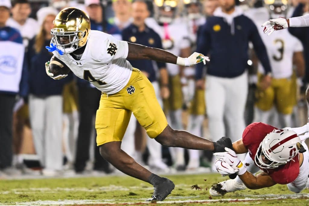 Stanford Cardinal safety Mitch Leigber (32) attempts to tackle Notre Dame Fighting Irish running back Jeremiyah Love (4) during a game between the Notre Dame Fighting Irish and Stanford Cardinal on November 29, 2025 at Stanford Stadium in Palo Alto, CA.