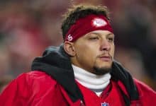 KANSAS CITY, MISSOURI - DECEMBER 07: Patrick Mahomes #15 of the Kansas City Chiefs looks on from the sideline during the national anthem prior to an NFL football game against the Houston Texans at GEHA Field at Arrowhead Stadium on December 7, 2025 in Kansas City, Missouri.