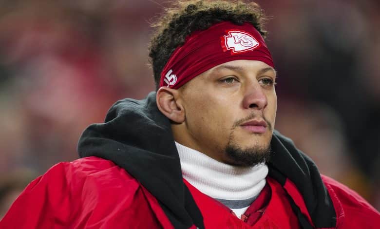 KANSAS CITY, MISSOURI - DECEMBER 07: Patrick Mahomes #15 of the Kansas City Chiefs looks on from the sideline during the national anthem prior to an NFL football game against the Houston Texans at GEHA Field at Arrowhead Stadium on December 7, 2025 in Kansas City, Missouri.