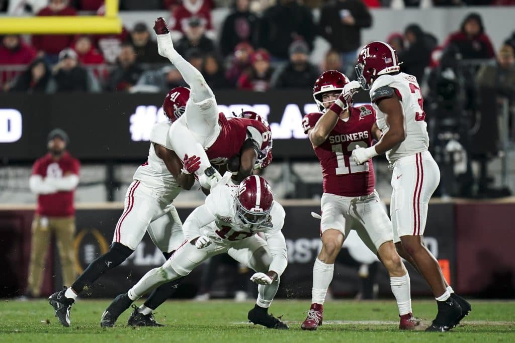 NORMAN, OKLAHOMA - DECEMBER 19: Tory Blaylock #6 of the Oklahoma Sooners is tackled by Justin Jefferson #10 of the Alabama Crimson Tide in the first half during a 2025 College Football Playoff First Round Game at Gaylord Family Oklahoma Memorial Stadium on December 19, 2025 in Norman, Oklahoma.
