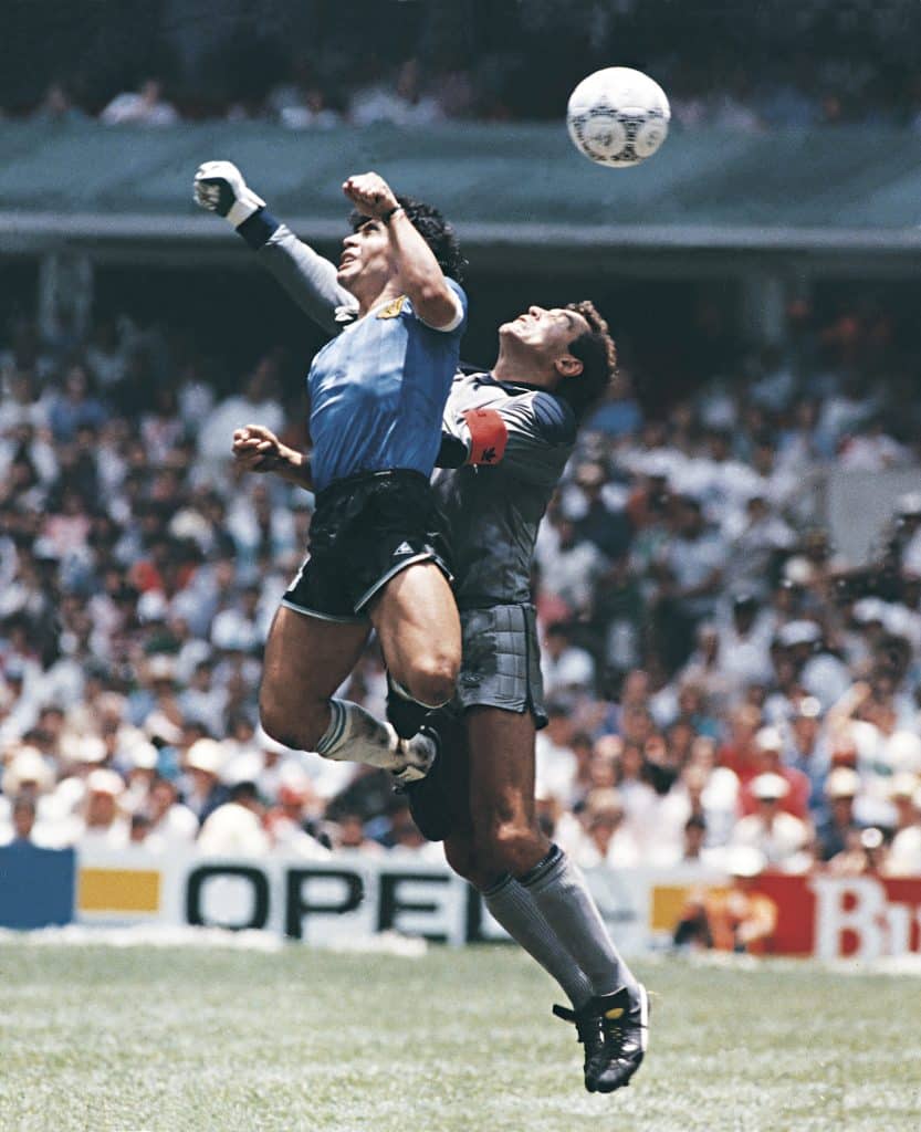 MEXICO CITY, MEXICO - JUNE 22: Diego Maradona of Argentina uses his hand to score the first goal of his team during a 1986 FIFA World Cup Quarter Final match between Argentina and England at Azteca Stadium on June 22, 1986 in Mexico City, Mexico. Maradona later claimed that the goal was scored by 'The Hand Of God'. 