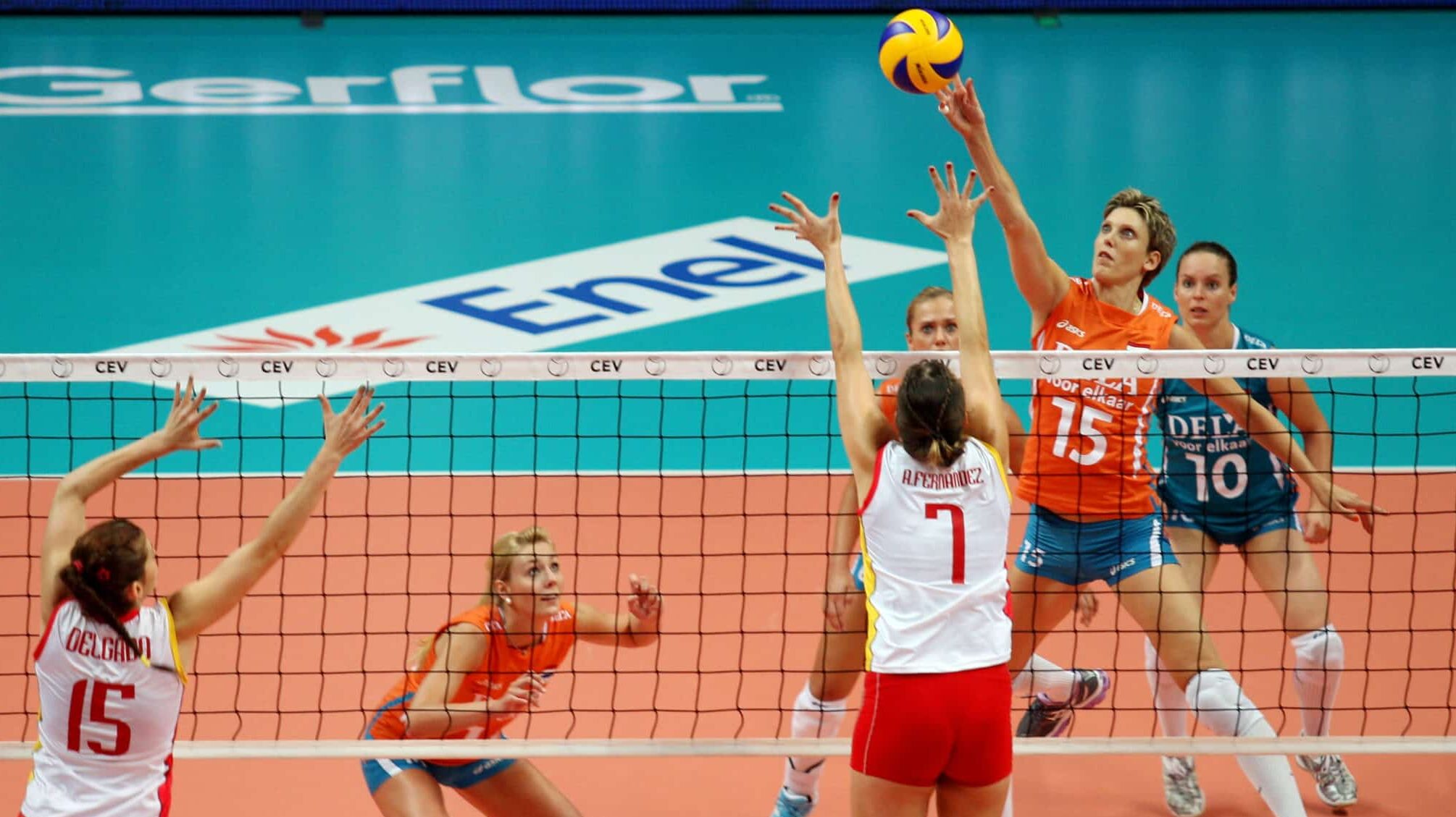 A jogadora de vôlei Ingrid Visser, da Holanda, no ar atacando a bola sobre o bloqueio de uma jogadora da Espanha