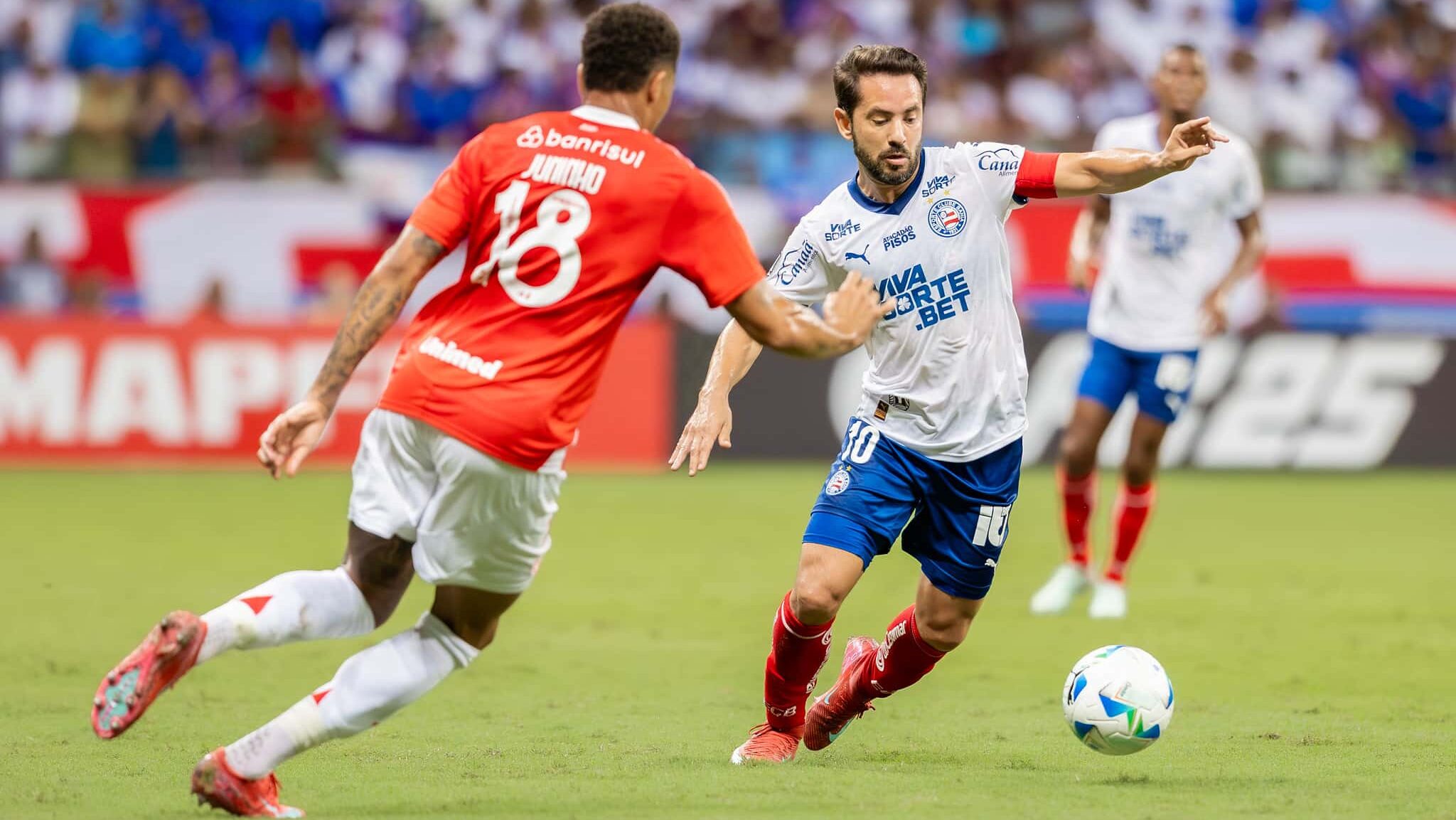 Jogador do Inter, de costas, tenta desarmar jogador do Bahia, que está com a bola