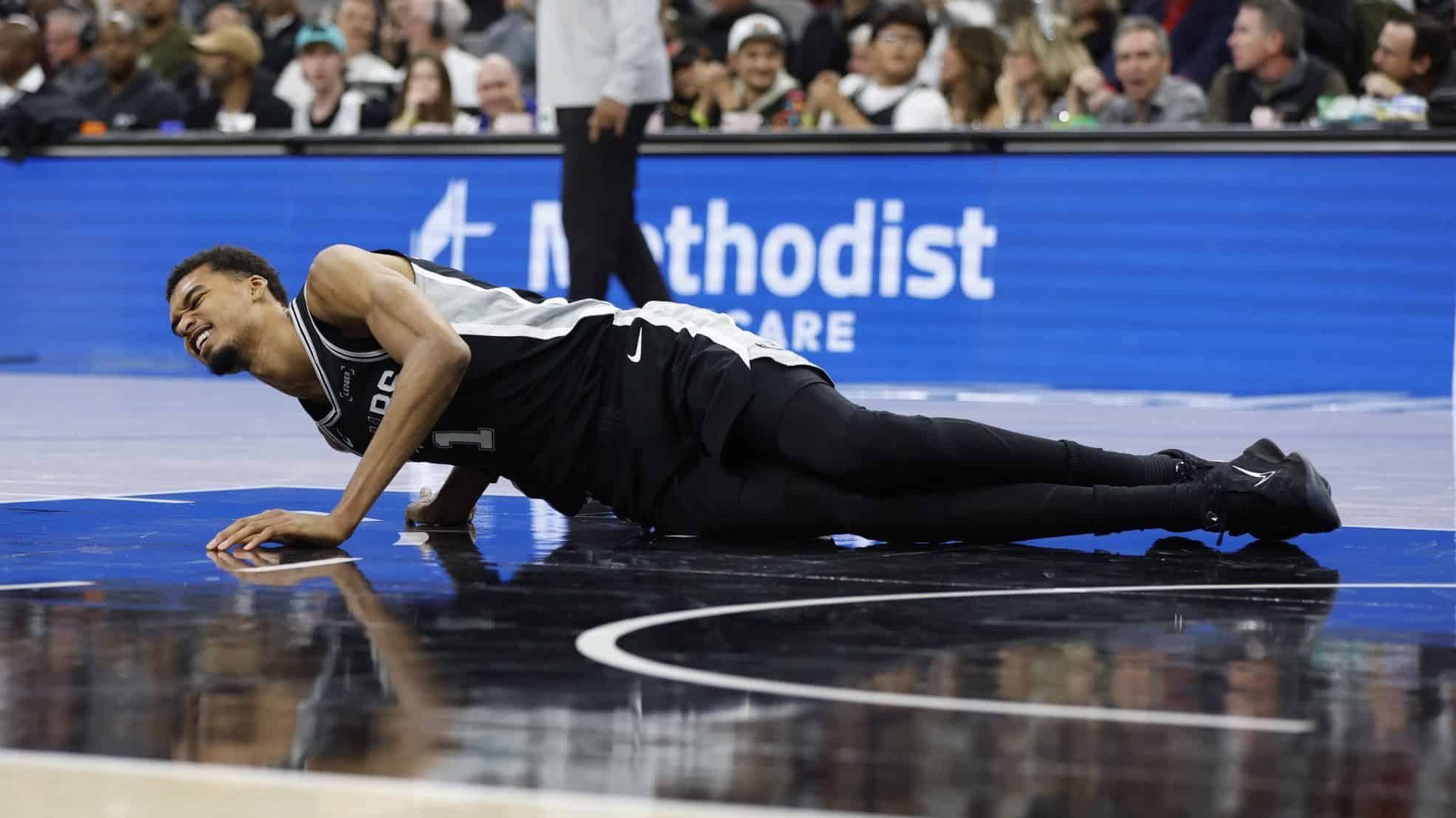 Wembanyama caído no chão após sofrer lesão